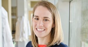 A woman with blonde hair smiling in a medical office.