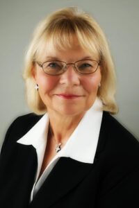Blond woman with glasses smiling. A professional woman with glasses.